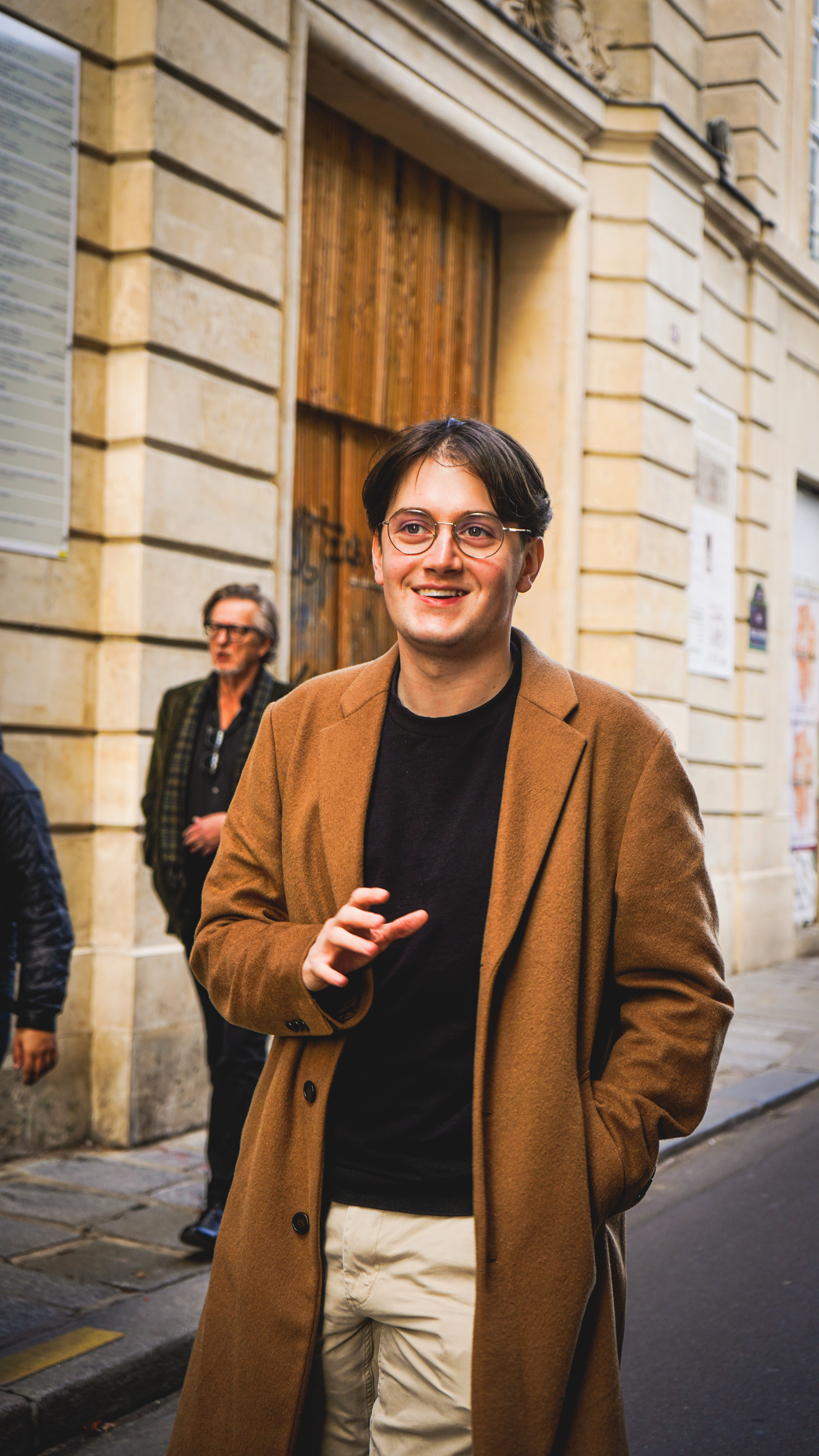 A young man in Paris is laughing while walking in the streets of Paris