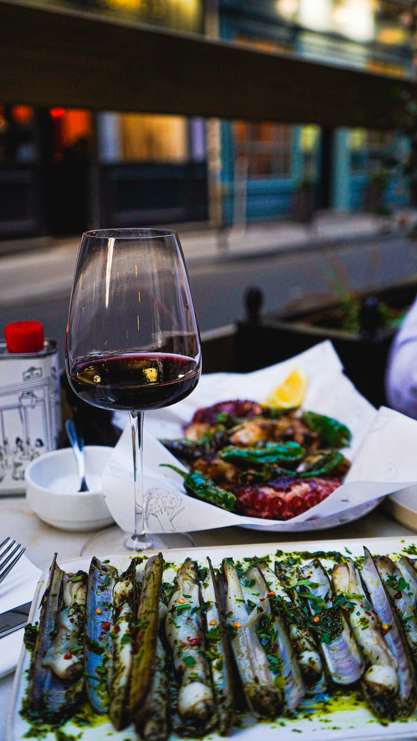 A table at a French restaurant in Paris, with a glass of red wine on the table